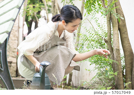 ジョウロで水やりをする若い女性 ガーデニングの写真素材