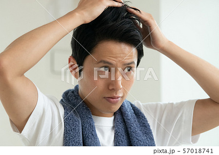 髪型を整える若い日本人男性　ヘアケア　ヘアセット 57018741