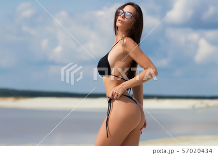 Beautiful woman in swimsuit on beach Beautiful woman in swimsuit on beach 57020434