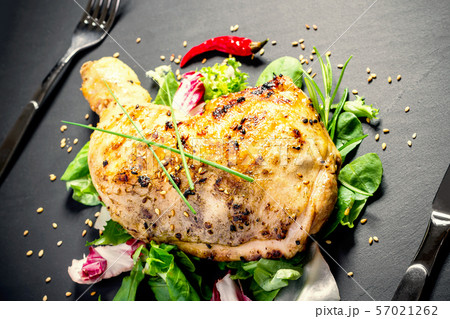 Grilled chicken thighs on slate plate Grilled chicken thighs on slate plate 57021262