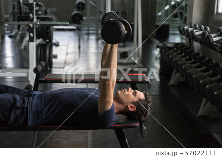 Handsome weightlifter lifting bench press working Handsome weightlifter lifting bench press working 57022111