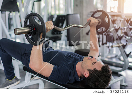 Handsome weightlifter lifting barbells bench press Handsome weightlifter lifting barbells bench press 57022118