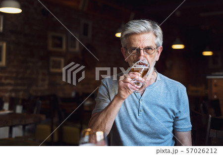 Senior man having a beer in the bar 57026212