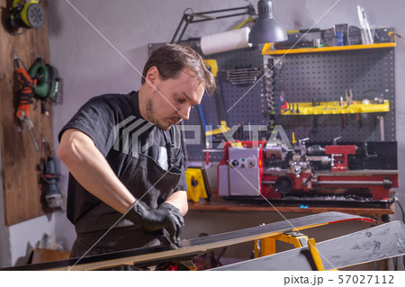A man repairing the ski in the service A man repairing the ski in the service 57027112