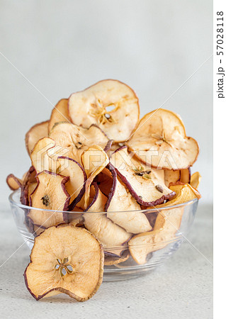 Hipped Dried apples chips in glass bowl on light 57028118