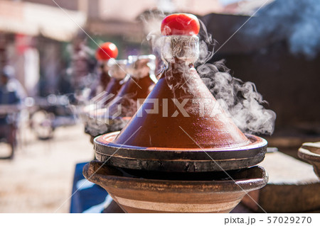 Authentic food of Morocco - traditional Tajine in steam vapor on an outdoor barbecue at town square Authentic food of Morocco - traditional Tajine in steam vapor on an outdoor barbecue at town square 57029270