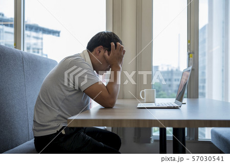 パソコンを前に座る男性の後ろ姿の写真素材