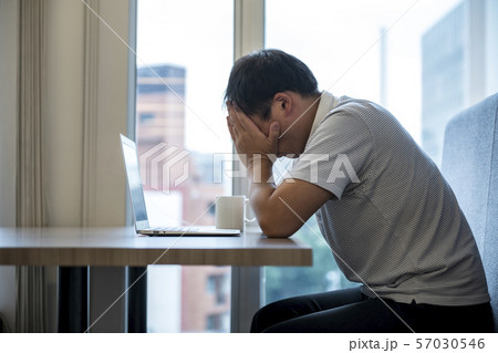 パソコンの前で頭を抱える男性 57030546