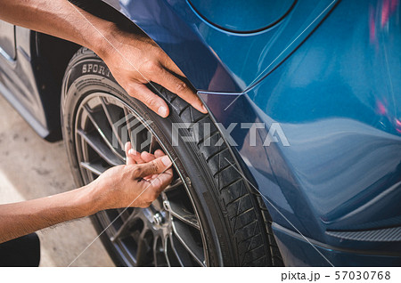 Closeup male automotive technician removing tire Closeup male automotive technician removing tire 57030768