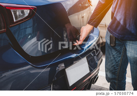 Closeup of man hand opening hatchback trunk by Closeup of man hand opening hatchback trunk by 57030774