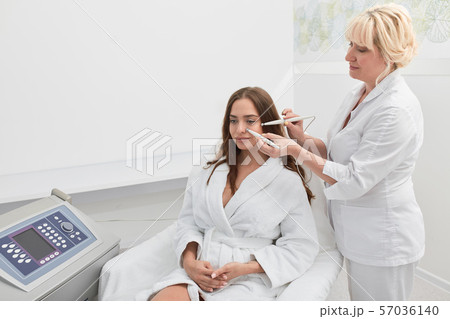 beautiful brunette young woman having relaxing procedure on her face 57036140