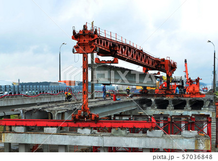 Repair of the automobile bridge over the railway. Mounting crane removes reinforced concrete beams. Repair of the automobile bridge over the railway. Mounting crane removes reinforced concrete beams. 57036848