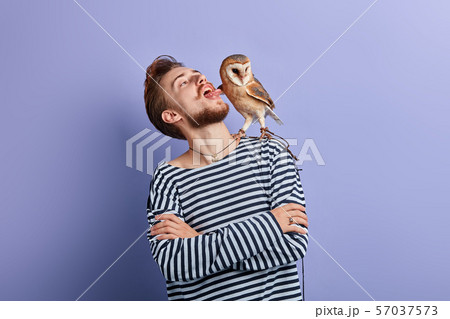 funny crazy man putting tongue out, looking at the owl 57037573