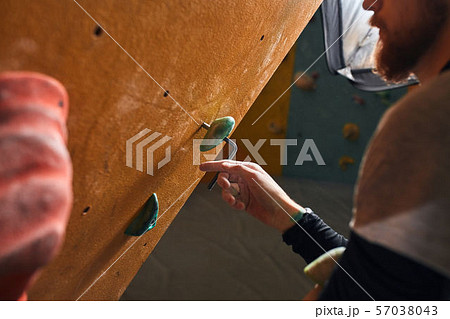 Close up view of unrecognizable climber with beard fixing artificial rock 57038043