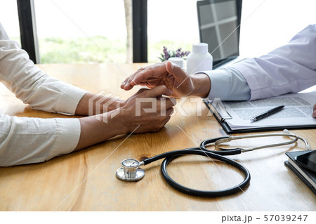Professor doctor touching patient hand for 57039247
