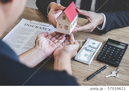 Estate agent giving house and keys to client after Estate agent giving house and keys to client after 57039621