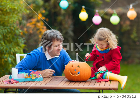 Family carving Halloween pumpkin. 57040512