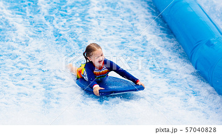 Little girl surfing in beach wave simulator 57040828