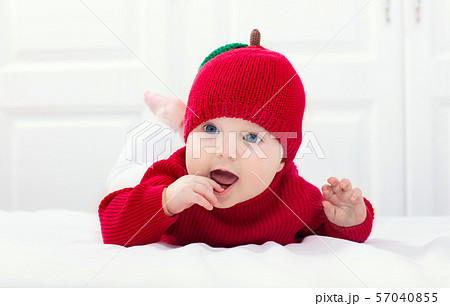 Baby in apple hat. Kid on bed. Child at home. Baby in apple hat. Kid on bed. Child at home. 57040855