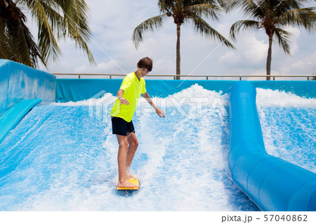 Teenager boy surfing in beach wave simulator 57040862