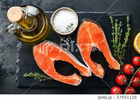 Salmon steaks and spices for cooking on black slate 57041120