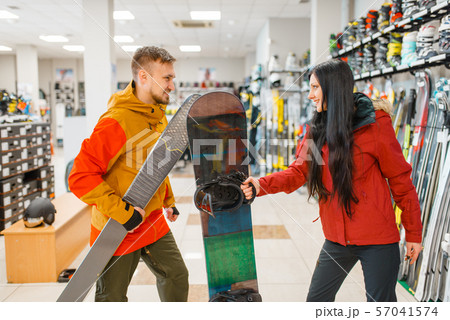 Couple buying downhill ski and snowboard, shopping 57041574