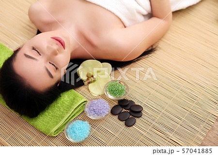 Cute relaxed young woman laying in spa salon with closed eyes Cute relaxed young woman laying in spa salon with closed eyes 57041885