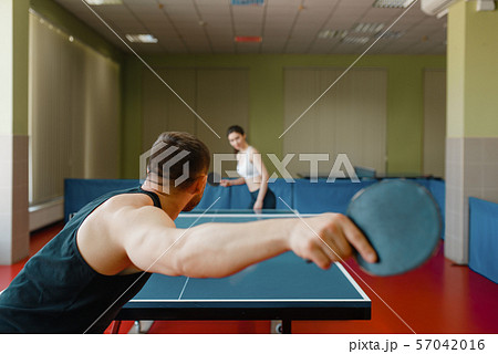 Man and woman playing ping pong, focus on racket 57042016