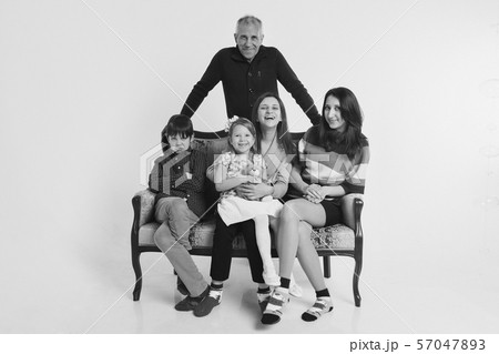 concept of happy childhood, family, love - group of people on a white background: adults and children with toys sitting on the same couch 57047893