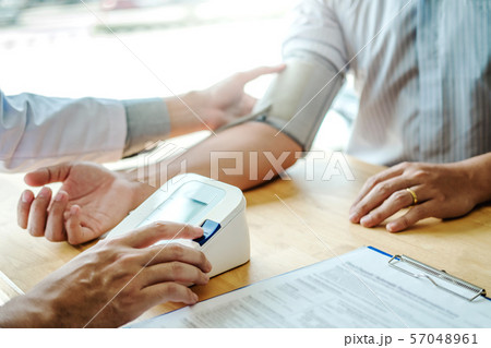 Doctor Measuring arterial blood pressure man 57048961