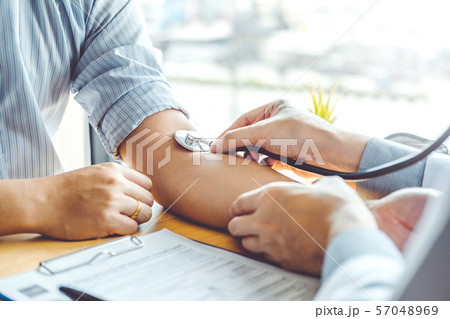 Doctor Measuring arterial blood pressure man 57048969