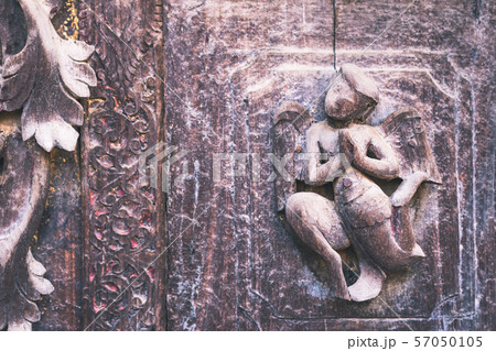 Archaeological, Close Up of carved art figures on old wood carvings on the wall temple at Shwe Nan Daw Kyaung (Golden Palace Monastery) in Mandalay, Myanmar 57050105