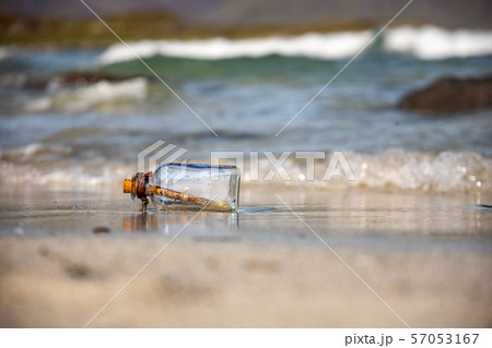 Message in the bottle against the Sun setting down 57053167