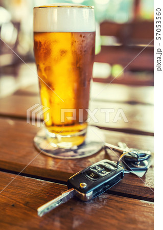 Car keys and glass of beer or distillate alcohol 57053560