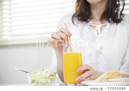 オレンジジュースを飲む女性・エコストロー 57055084