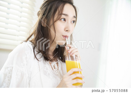 オレンジジュースを飲む女性・エコストロー 57055088