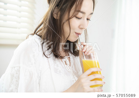 オレンジジュースを飲む女性・エコストロー 57055089