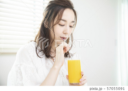 オレンジジュースを飲む女性・エコストロー 57055091