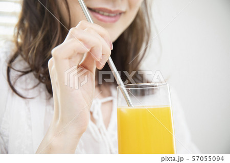 オレンジジュースを飲む女性・エコストロー 57055094