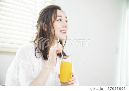 オレンジジュースを飲む女性・エコストロー 57055095