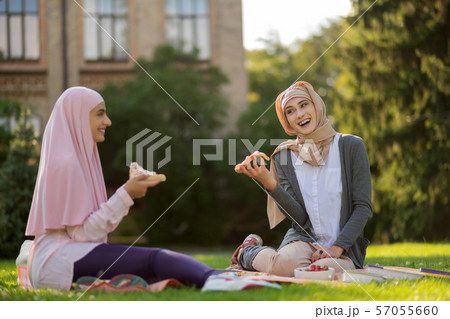 Muslim students laughing and eating pizza enjoying lunch break Muslim students laughing and eating pizza enjoying lunch break 57055660