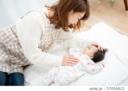 赤ちゃんを寝かしつける保育士 赤ちゃんを寝かしつける保育士 57056022