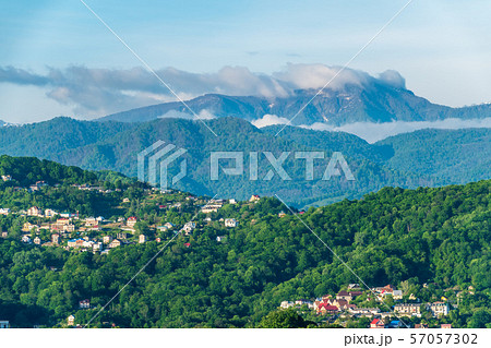 View on a green hilly valley with houses 57057302