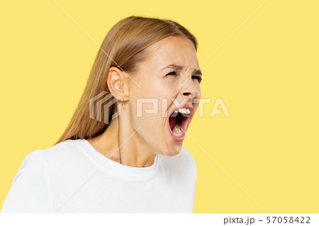 Caucasian young woman's half-length portrait on yellow background 57058422