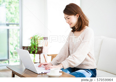 部屋でパソコンを使う若い女性 57059964
