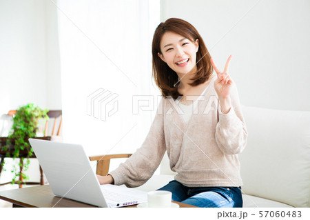 部屋でパソコンを使う若い女性 57060483