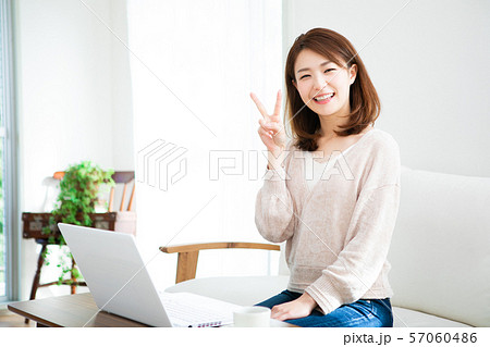 部屋でパソコンを使う若い女性 部屋でパソコンを使う若い女性 57060486