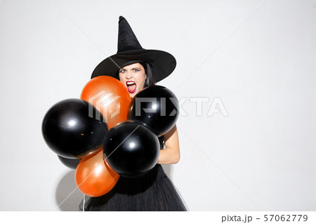 Young woman in hat and dress as a witch on white background Young woman in hat and dress as a witch on white background 57062779