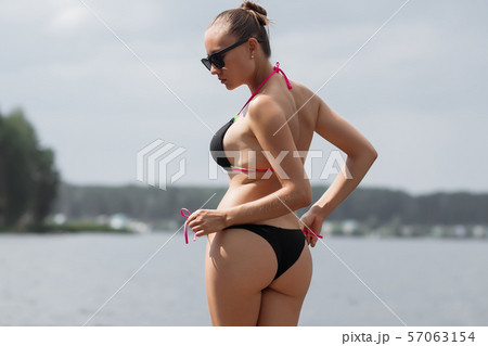 Sexy woman taking off panties on beach - Stock Photo [68271302