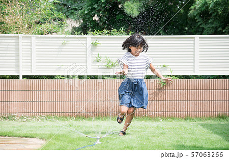 庭で水遊びをする女の子の写真素材